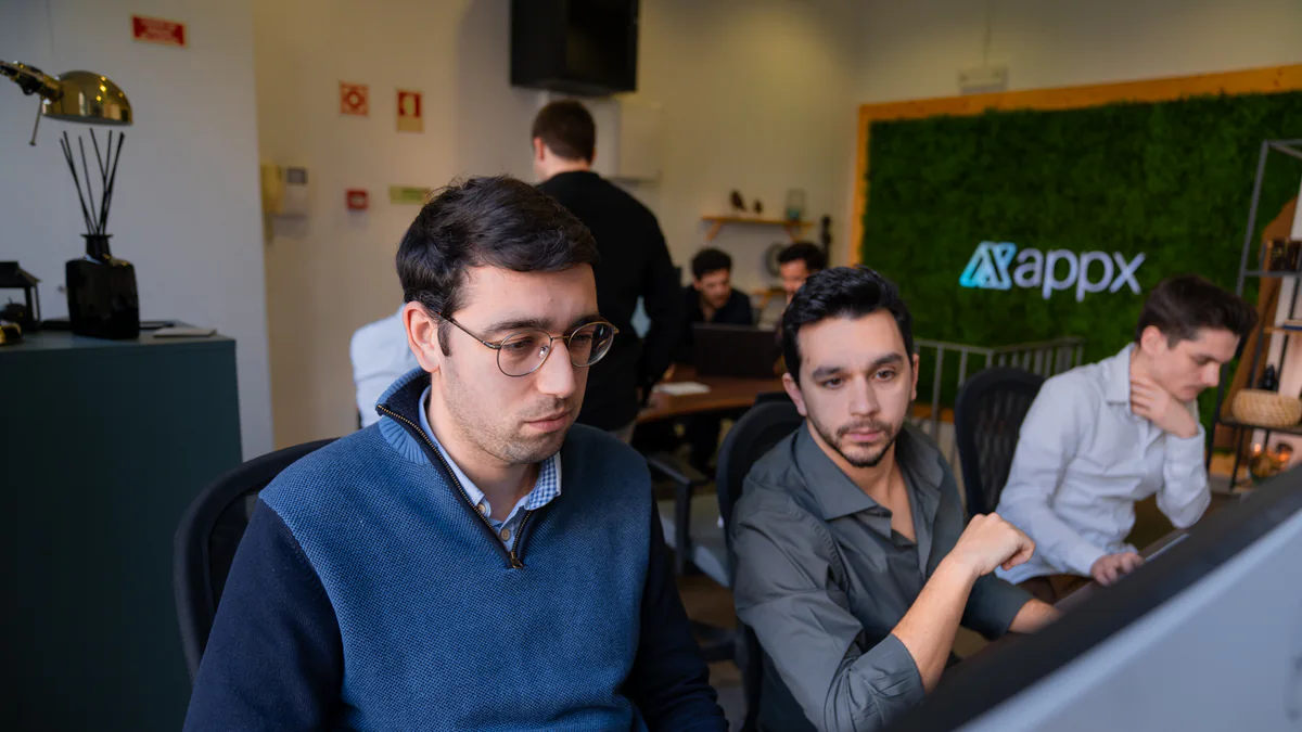 Three of the AppX team gathered around one screen