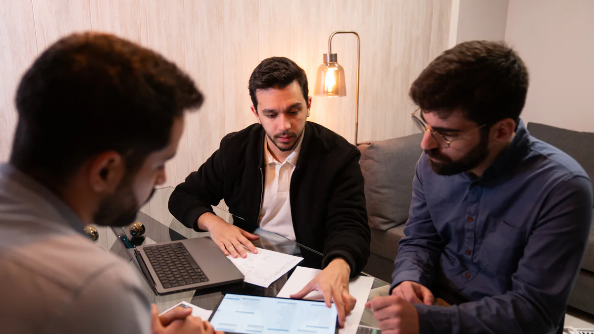 An AppX working session around a laptop, a tablet and printed plans