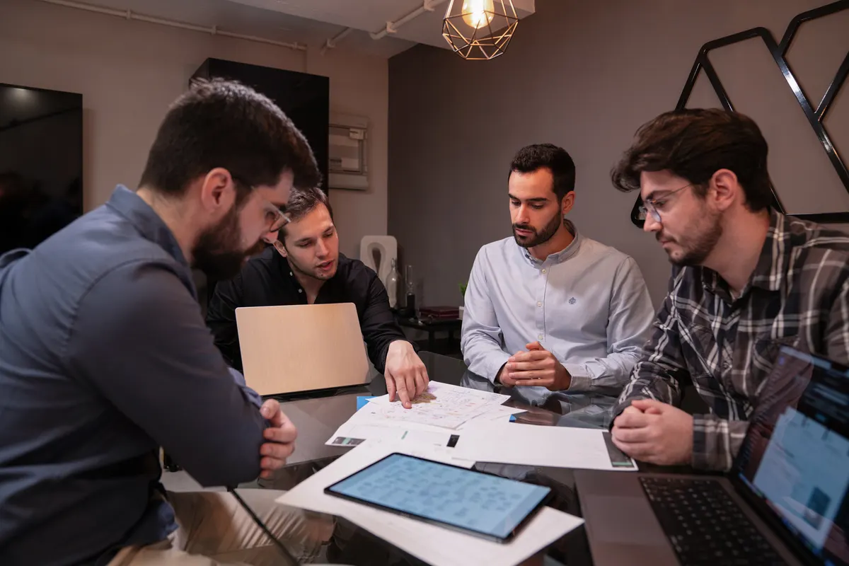 Four of the AppX team around a table, going through work